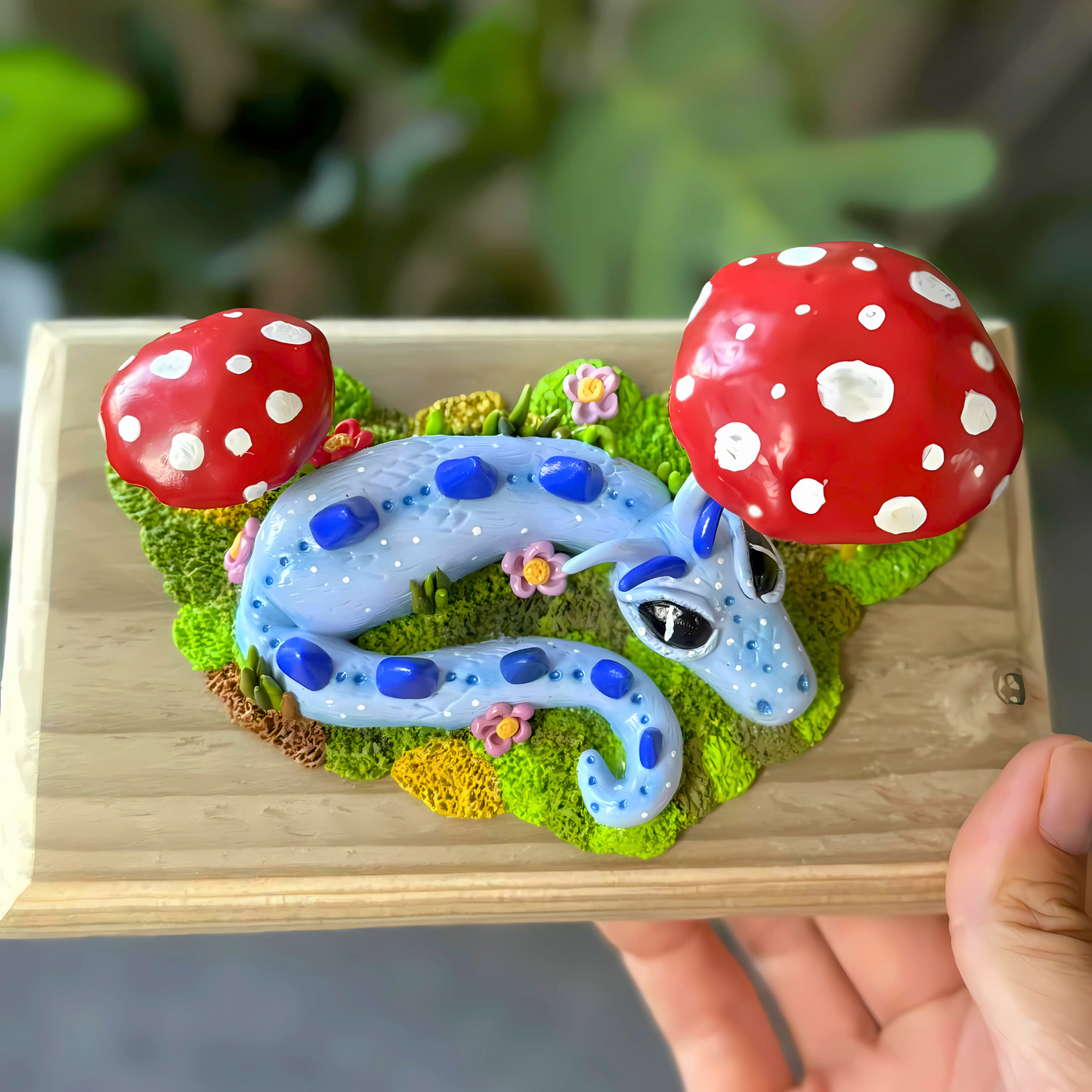 Whimsical Blue Dragon Figure Laying Amongst The Mushrooms.