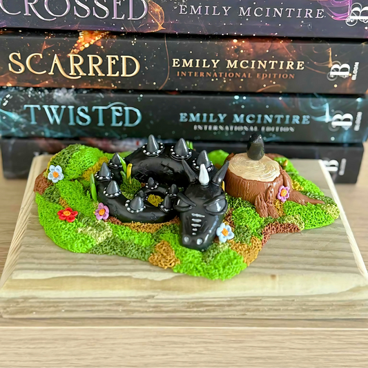 Whimsical Black Dragon Figure Laying In The Grass.